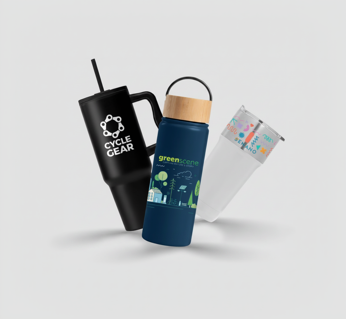 Black tumbler with Cycle Gear logo, blue water bottle with green scene design, and colorful pouch on a light gray background.